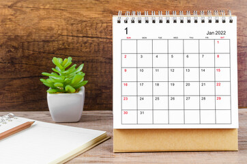 January desk calendar 2022 on wooden background.