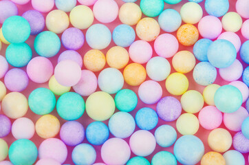 Foam beads of various colors brightly colored background.