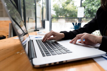 Close up of businessman or accountant working on laptop computer for calculate business data, accounting document and calculator at office, business concept