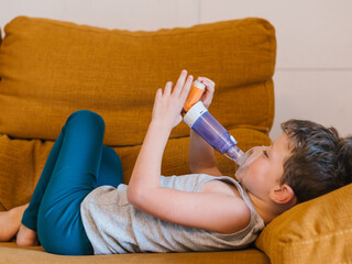 Ill child using inhaler at home