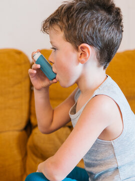 Ill child using inhaler at home