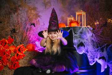 Little cute blonde girl dressed as a witch on a gloomy background. Decorations for All Saints Day. Halloween costume. Child in a sorceress hat