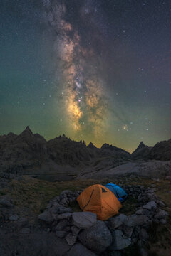 Tent in river against mount under starry sky
