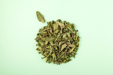 Dried mint leaves for making herbal medicinal tea. Top view, Light green background, copy space