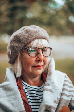 Close up photo of cheerful woman enjoy autumn travel fall trip. Happy caucasian woman in a glasses in a sweater enjoys relaxes outdoors on a warm autumn day.