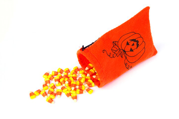 orange felt bag with pumpkin with Halloween candy corn spilling out
