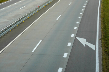 Photo of a gray road with white road markings