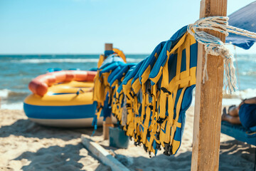 many colorful yellow blue life jacket or life vest hanging on a clothesline