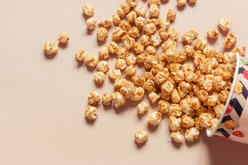 sweet popcorn in paper packaging scattered on the background
