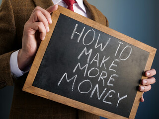 Advisor holds blackboard with words How to make more money.