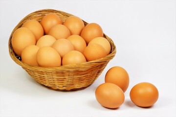 Eggs in a basket, isolated on a white background. The food product has an oval shape, consists of protein and yolk. Chicken eggs are widely used in cooking.