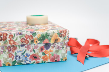 decorated box with letter paper ribbon and stationery on a white background