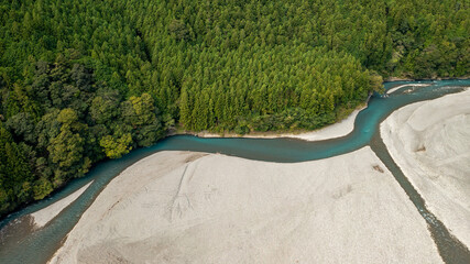 A jade-colored river that forms a large sandbar and flows through the mountains A