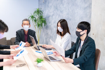 マスクをして会議をするビジネスパーソン