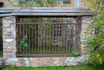 Medieval wall with grate. Part of stone wall of a medieval fortress
