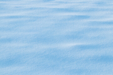 Snowy background, snowy surface with a clearly expressed texture of snow in the morning sun