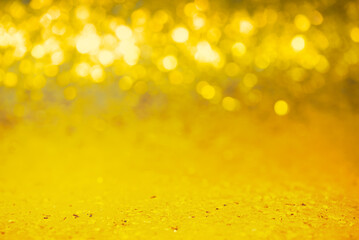 Very narrow focal area of a glitter background. Gold color sequins with defocus light. Christmas.