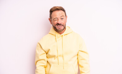 middle age handsome man looking happy and friendly, smiling and winking an eye at you with a...