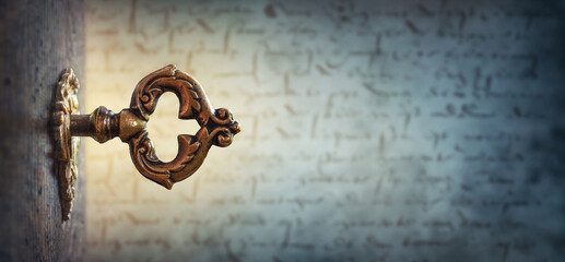 An old key in a keyhole on the background of an ancient manuscript, macro photography. Retro style....