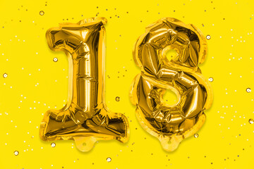 The number of the balloon made of golden foil, the number eighteen on a yellow background with sequins. Birthday greeting card with inscription 18. Numerical digit, Celebration event, template.