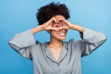 Photo of young african girl watch eye gesture heart figure romance date feelings isolated over blue color background