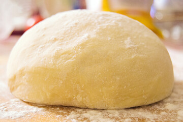 Fototapeta na wymiar soft fluffy dough with wheat flour on the table close-up
