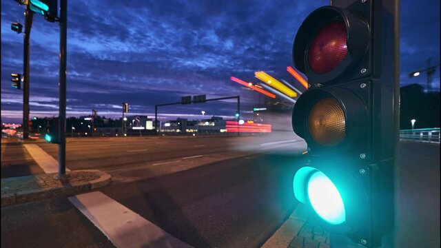 Timelapse of the traffic light near the busy street in a European city in the evening