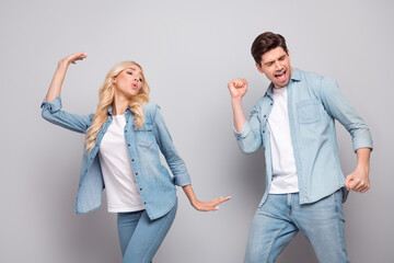 Photo of two carefree funny positive people dance enjoy party wear jeans outfit isolated grey color background