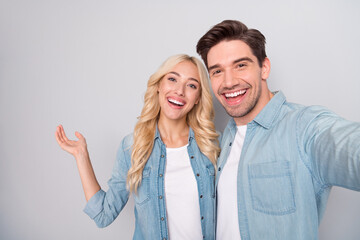 Fototapeta premium Self-portrait of attractive cheerful couple hugging having fun isolated over gray pastel color background