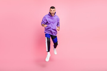 Fototapeta na wymiar Full size photo of funky millennial brunet guy run wear hoodie pants shoes isolated on pink background