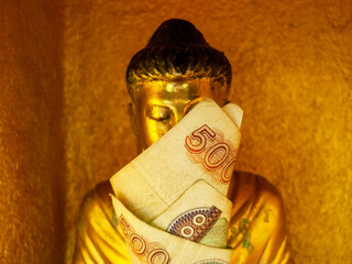 A golden Buddha statue on Mount Popea, one of the three major Buddhist holy sites in Myanmar, holds...