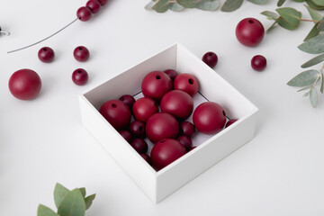 Red wooden beads in the white box. The process of creating hand made decorative wreath