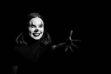 Emotional Portrait of a scary clown woman on a dark background. Halloween.