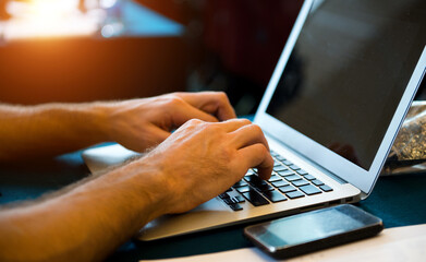 Human hands typing on laptop keyboard.