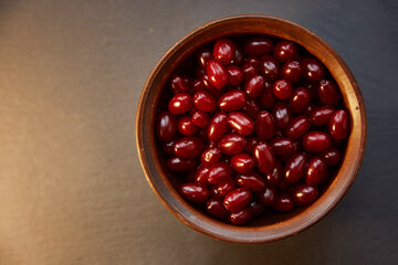Natural healthy dogwood berry in the clay bowl. Autumn healthy food for vitamin compote or tea. Copy space