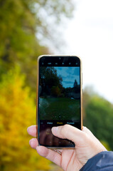 autumn nature landscape photo on smartphone in male hand