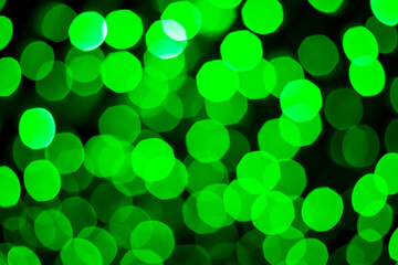 Defocused Green abstract bokeh lightson black background.
