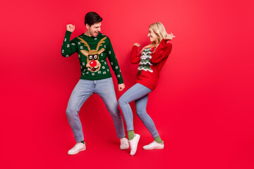 Fototapeta na wymiar Photo of dreamy inspired couple dance have x-mas fun wear ugly sweater jeans shoes isolated red color background