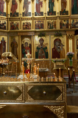 Fototapeta na wymiar Burning candles on the background of the altar in an Orthodox church. Faith and Prayer. Vertical.