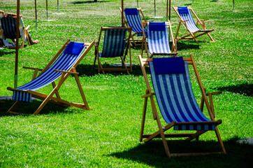 View of Biblioteca degli Alberi (BAM), park located between Piazza Gae Aulenti and the Isola district. City center and skyscrapers. Milan. Italy. 06-26-2021. Deck chairs and people relaxing