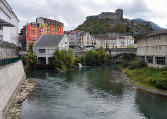 Fototapeta na wymiar Lourdes, France - 9 Oct, 2021: Views along the River Ousse towards Lourdes Castle and Pyrenees Museum