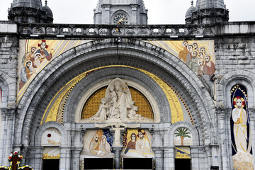Lourdes, France - 9 Oct, 2021: Religious artwork and mosaics at the entrance to the Sanctuary de Notre Dame Cathedral, Lourdes