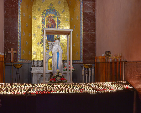 Lourdes, France - 9 Oct, 2021: Candles at a shrine to the Virgin Mary within the Rosary Basilica Church