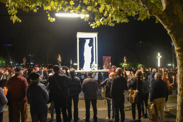 Lourdes, France - 9 Oct 2021: A Statue of the Virgin Mary is carried among the crowds during the Marian Torchlight Procession at the Rosary Basilica in Lourdes