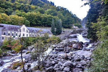 Fototapeta na wymiar Cauterets, France - 10 Oct 2021: Waterfalls cascade from the Pyrenees mountains near La Raillere springs