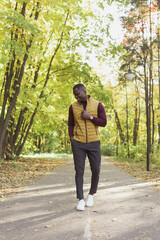 African american student walking in the park in autumn season