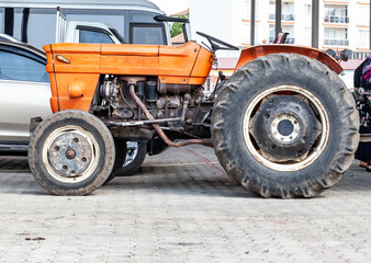 Obraz premium An old vintage red rusted tractor sitting in a fenced pasture in an agricultural rural summer countryside landscape.