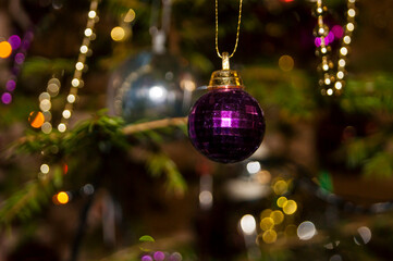 Christmas toys against the background of green branches and lights