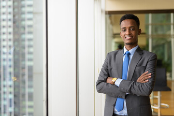 Portrait of handsome African businessman wearing suit and tie with arms crossed