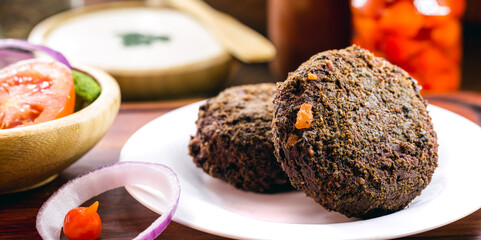 alternative burger made from black beans, vegetables, beets, wholemeal flour and quinoa, with various vegetables.
